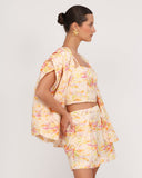 Vista lateral de short floral en lino con corte sastrero y tiro alto estilo resort